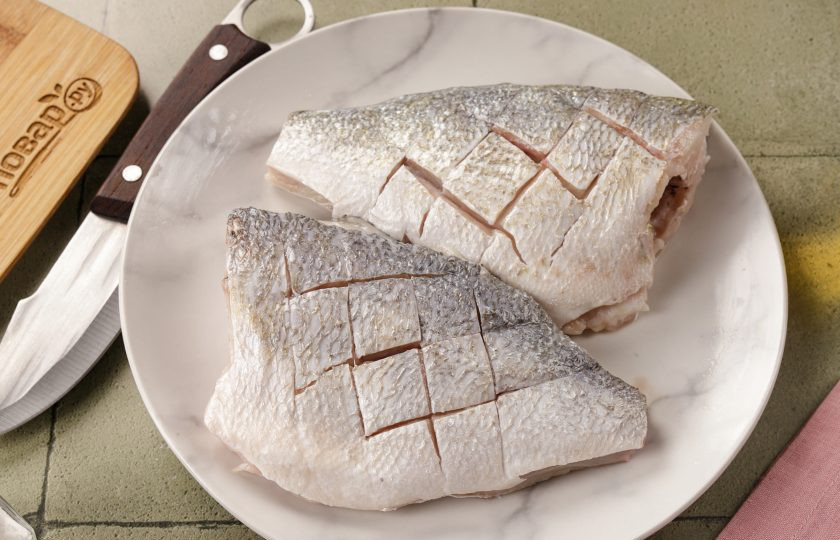 1. Этап. Дорадо в аэрогриле: При помощи острого ножа на боковых частях сделайте неглубокие крестообразные или поперечные разрезы, чтобы при жарке она лучше пропиталась соком и специями.