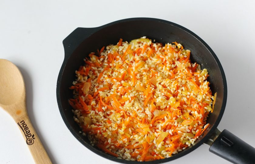 1. Этап. Курица на рисовой подушке: Добавьте промытый рис, соль по вкусу и прогрейте все вместе еще пару минут.