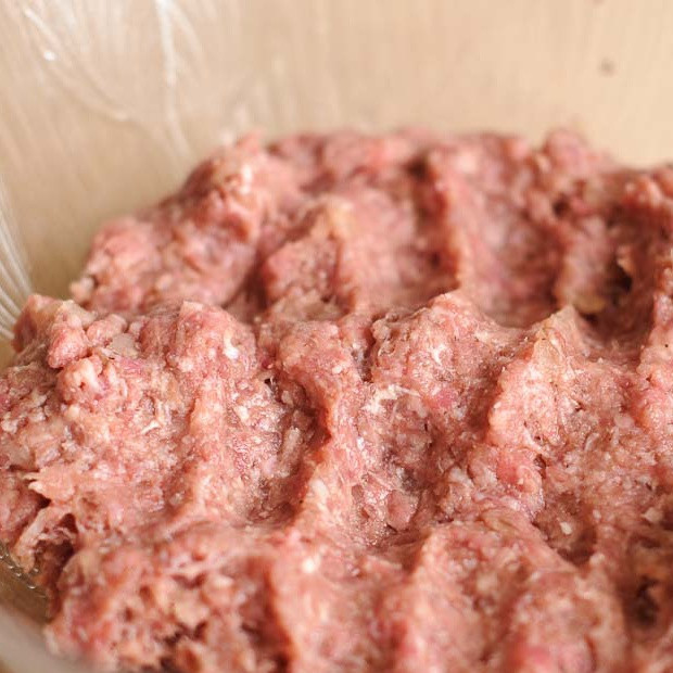 1. Этап. Суп с фрикадельками из говяжего фарша: Пропустить лук через мясорубку и смешать с фаршем. Добавить тмин, соль, черный перец и яичный белок. Хорошенько перемешать.