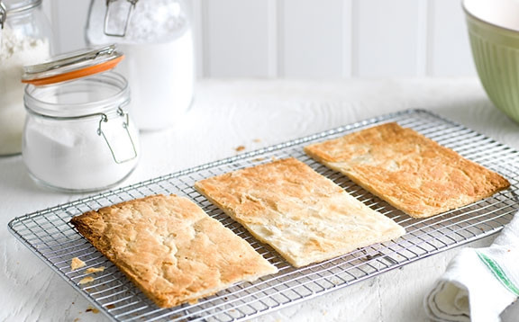 1. Этап. Сливочный мильфей: 1. Разморозьте слоенное тесто, раскатайте его в прямоугольник и поделите на три части. Запекайте тесто в духовке при температуре 180 градусов 15-20 минут.