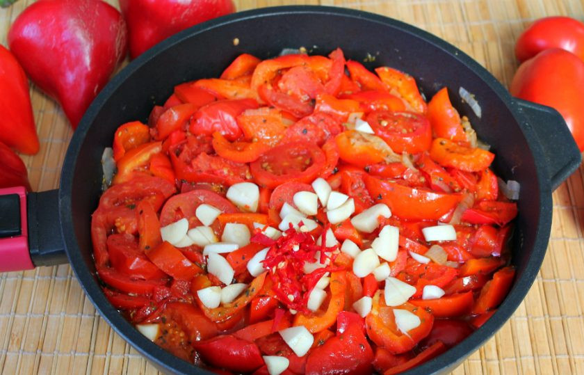 1. Этап. Салат из сладкого перца и помидоров на зиму: Добавляем нарезанный чеснок и немного острого перца. Готовим еще 5 минут и перекладываем кипящий салат в стерильную банку. Закатываем металлической крышкой.