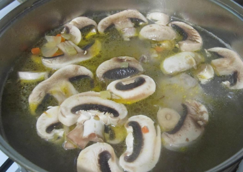1. Этап. Суп вермишелевый с грибами: Добавьте в кастрюлю вермишель, порезанные пластинками грибы, зажарку, соль и перец по вкусу. Перемешайте и доведите до кипения.