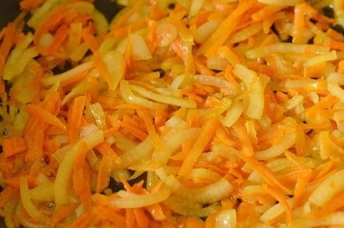 1. Этап. Рыбные котлеты из судака: Очистите лук и морковь. Нарежьте лук полукольцами, а морковку натрите на крупной терке. Можете нашинковать ее соломкой при желании. Обжарьте их с маслом в отдельной сковородке, добавив томатную пасту, муку и лавровый лист.