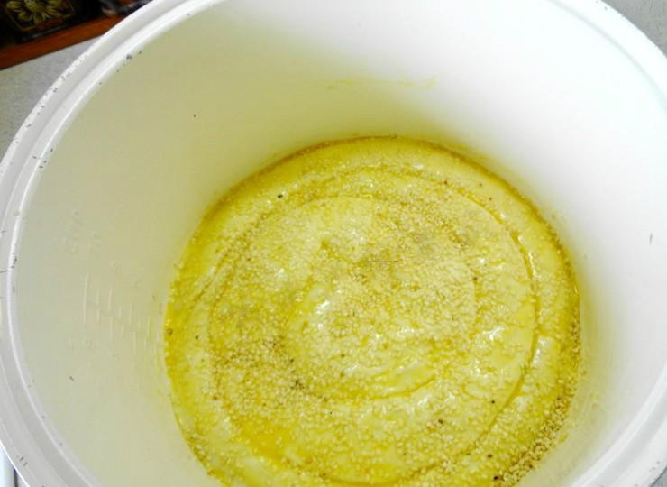 1. Этап. Пирог из слоеного теста в мультиварке: Чашу мультиварки смазываем маслом. На нее выкладываем колбаски, формируя спираль. Открытые концы колбасок соединяем друг с другом. Пирог смазываем желтком и посыпаем кунжутными семенами.