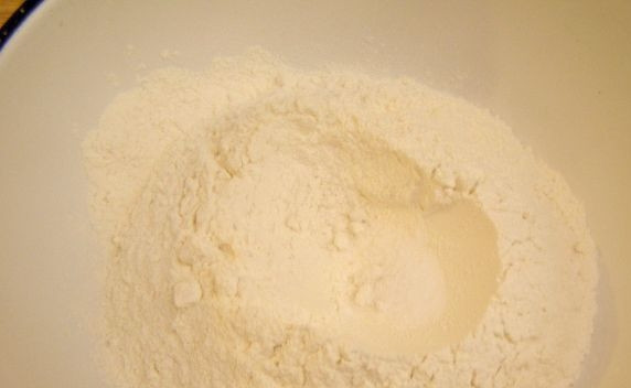 1. Этап. Тесто на лазанью: В муку добавьте щепотку соли. Всыпьте её в миску. В середине сделайте углубление.