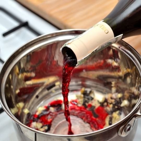 1. Этап. Паста с красным соусом: Кладем нарезанный чеснок, жарим 1 минуту, после чего добавляем специи. Еще через минуту вливаем вино, перемешиваем и тушим 2 минуты.