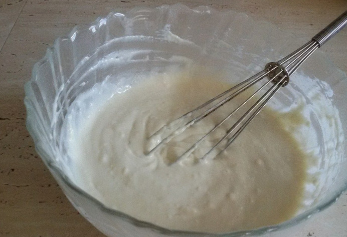 1. Этап. Пышные оладьи на кефире: В миске смешиваем кефир с сахаром. Вводим соль и соду, после чего постепенно подсыпаем муку. Непрерывно помешивая, доводим тесто до густой консистенции.