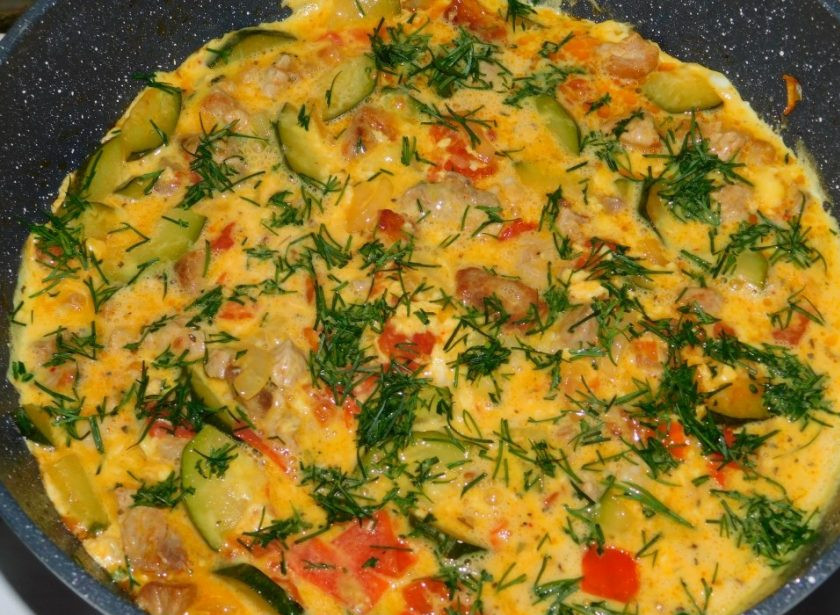 1. Этап. Мясной омлет с кабачками и помидорами: Залейте яичной массой овощи с мясом. Посыпьте укропом и готовьте под крышкой на маленьком огне минут 5-8.