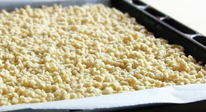 1. Этап. Торт Муравейник из детства: 4. Пропустите охлажденное тесто через мясорубку. Выложите его на пергаментную бумагу, застеленную на противень.