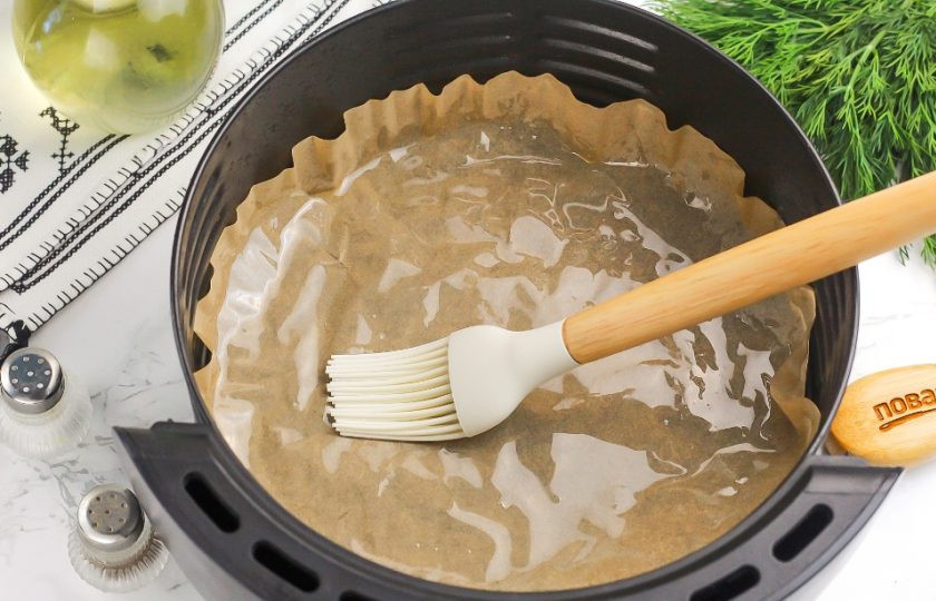 1. Этап. Мясо по-французски в аэрогриле: Чашу аэрогриля застелите пергаментной бумагой и смажьте ее растительным маслом, чтобы не пристал ко дну.
