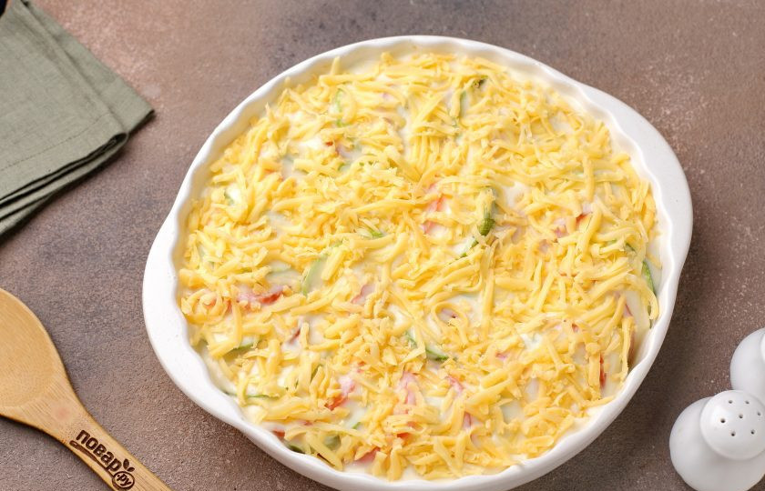 1. Этап. Запеканка Южная с кабачками и помидорами: Залейте овощи соусом и посыпьте тёртым сыром. Запекайте в духовке при температуре 180 градусов около 30-40 минут до румяной сырной корочки.