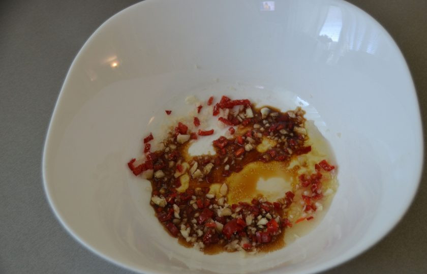 1. Этап. Битые огурцы по-китайски: Выложите в чашу чеснок, перец чили, добавьте смесь сахара с уксусом, влейте соевый соус и кунжутное масло.