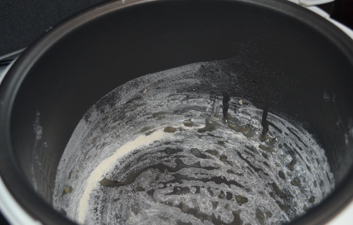 1. Этап. Брауни в мультиварке: Дно кастрюли мультиварки смажьте растительным маслом и присыпьте мукой.