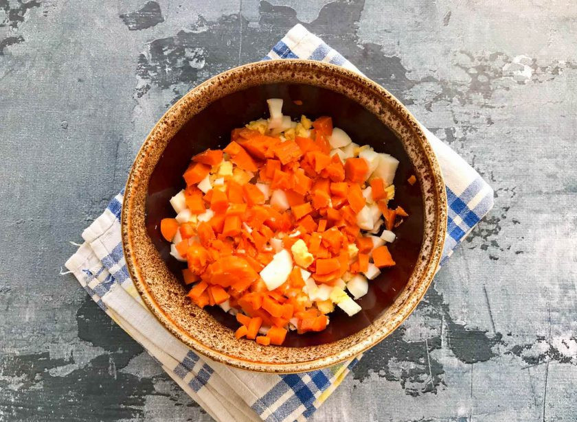 1. Этап. Салат Застольный с курицей: Вареную морковь почистите и нарежьте маленькими кусочками.