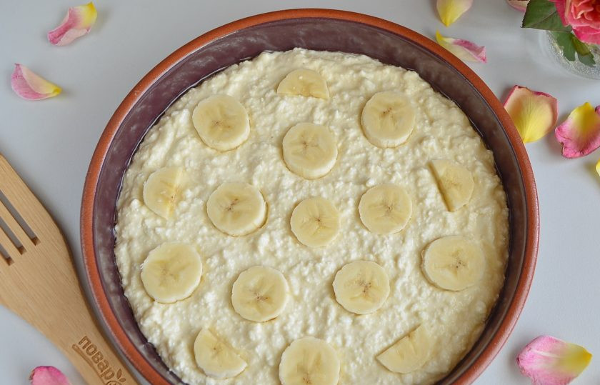 1. Этап. Творожная запеканка с бананами: Смажьте растительным маслом огнеупорную форму, выложите и разровняйте творожную массу. Сверху положите кружочки бананов.