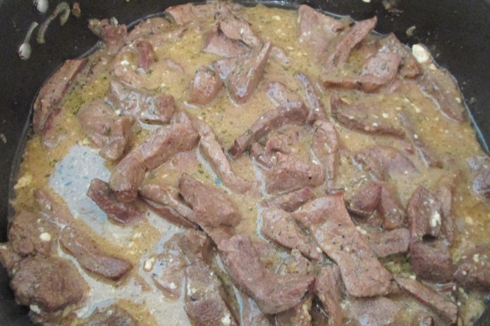 1. Этап. Печень, тушенная в соусе: Добавьте соевый соус. Тушите 10 минут. Затем добавьте сметану, влейте оставшуюся воду. Добавьте специи, перемешайте. Доведите до кипения и тушите еще 5 минут.