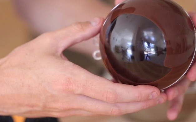 1. Этап. Шоколадный шар в домашних условиях: 3. Быстро поворачивайте шарик в разные стороны, чтобы шоколад равномерно распределился и шар был полностью заполнен.