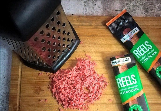 1. Этап. Слойки с колбасками и сыром: Колбаски натираем на тёрке средней величины. Они натрутся всё-равно мелко. Отправляем в посуду.