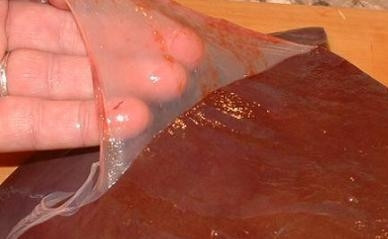 1. Этап. Печеночный торт из говяжьей печени: Подготовим печень. Удалим с неё пленку, вырежем протоки. Затем нарежем печень на кусочки и замочим на 2 часа в молоке.