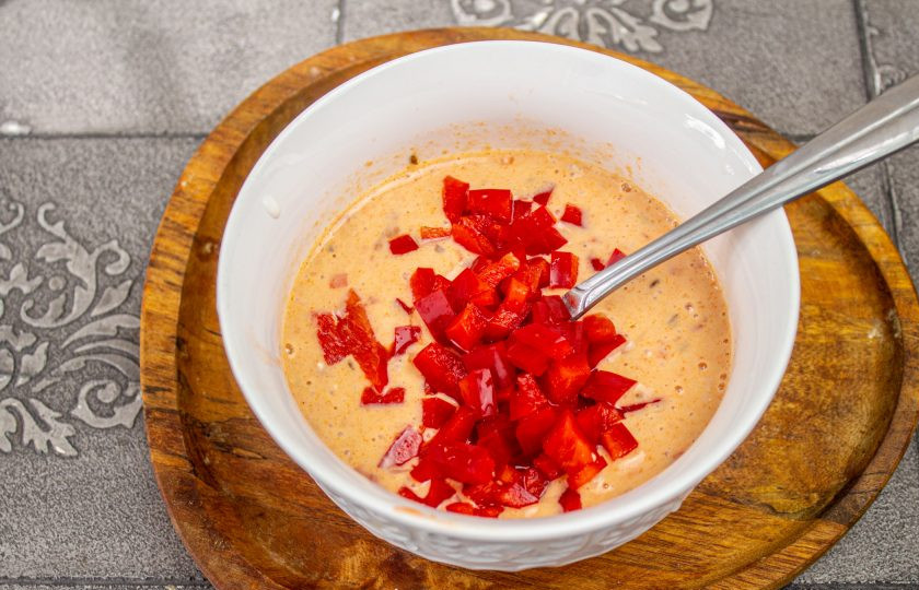 1. Этап. Трёхслойный торт-омлет: Перемешайте омлетную массу, добавьте мелко нарезанный болгарский перец. Вылейте массу в сковороду с 1 столовой ложкой масла и обжарьте как предыдущие под крышкой при небольшом нагреве.