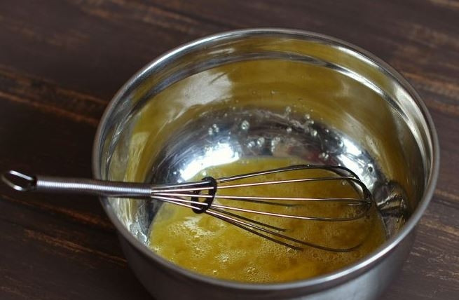 1. Этап. Дрожжевые блины на кислом молоке: Возьмите чистую глубокую миску, вбейте в нее сырые куриные яйца. Взбейте их немножко венчиком до появления небольшой пены.