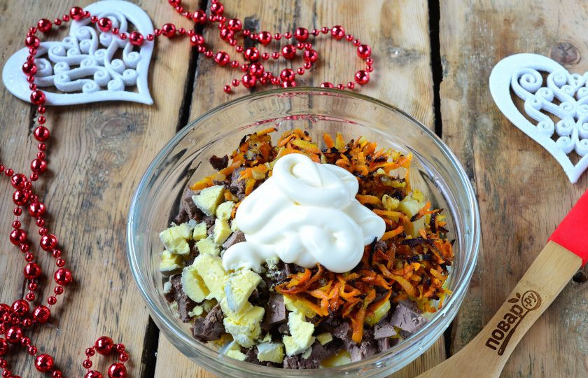 1. Этап. Новогодний салат в Год Собаки: Мелко порежьте яичные желтки и добавьте в салат. Заправьте все майонезом.