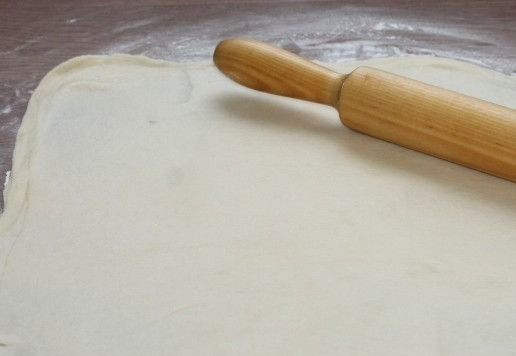 1. Этап. Пирожки из слоеного теста на кефире: 12. Подпыляем разделочную доску мукой и раскатываем каждую стопку в пласт, толщиной 2 мм.