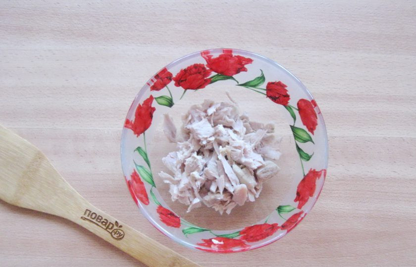 1. Этап. Салат Багратион: Отварную курицу нарежьте и выложите в салатник.