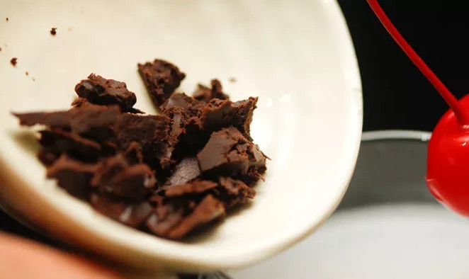 1. Этап. Коктейль Тройка: 3. А теперь помещаем тертый шоколад на дно стакана, а вишню подвесим так, чтобы она была в стакане, но над шоколадом. Я же просто взяла две вишни, одну поместила сверху, а другую снизу.