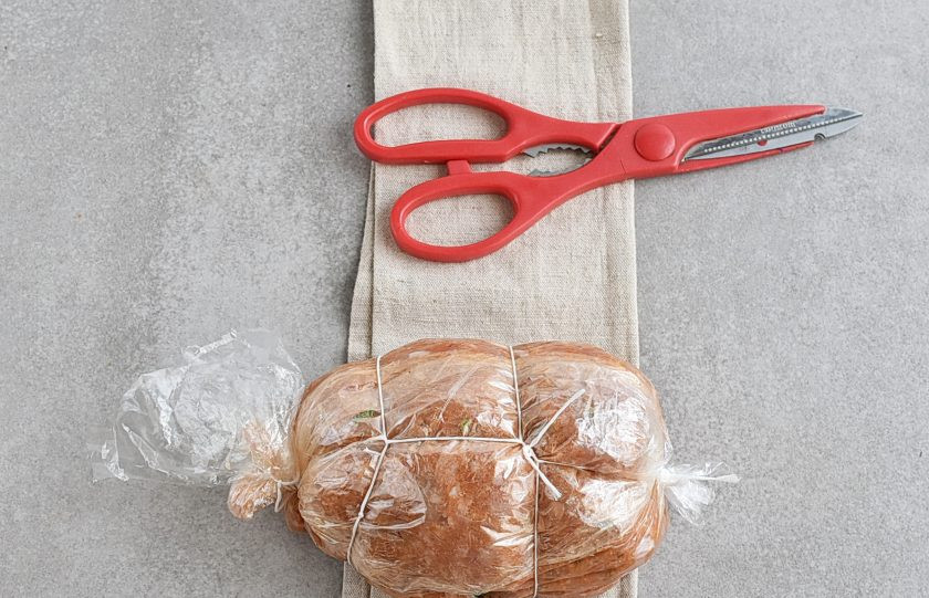 1. Этап. Домашняя ветчина из курицы: Уплотните фарш по всей длине, постукивая пакетом по столу. Подверните лишнюю ширину рукава вокруг будущей ветчины. Заверните второй край и завяжите его. Перетяните ветчину ниткой вокруг на манер колбасы. Все это в дальнейшем так же облегчит нарезку ветчины.