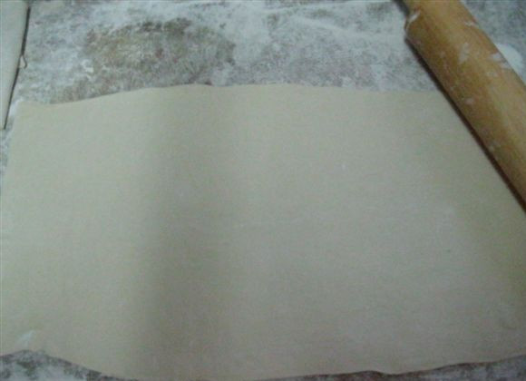 1. Этап. Пирожки из слоеного теста без дрожжей: 6. Слоеное тесто немного раскатать на присыпанной мукой поверхности.