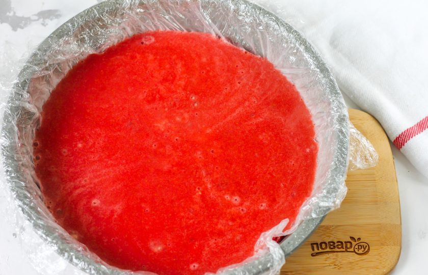 1. Этап. Клубничное конфи для торта: Застелите форму пищевой пленкой и вылейте в нее клубничную заготовку. Поместите в морозильную камеру на 40-60 минут.