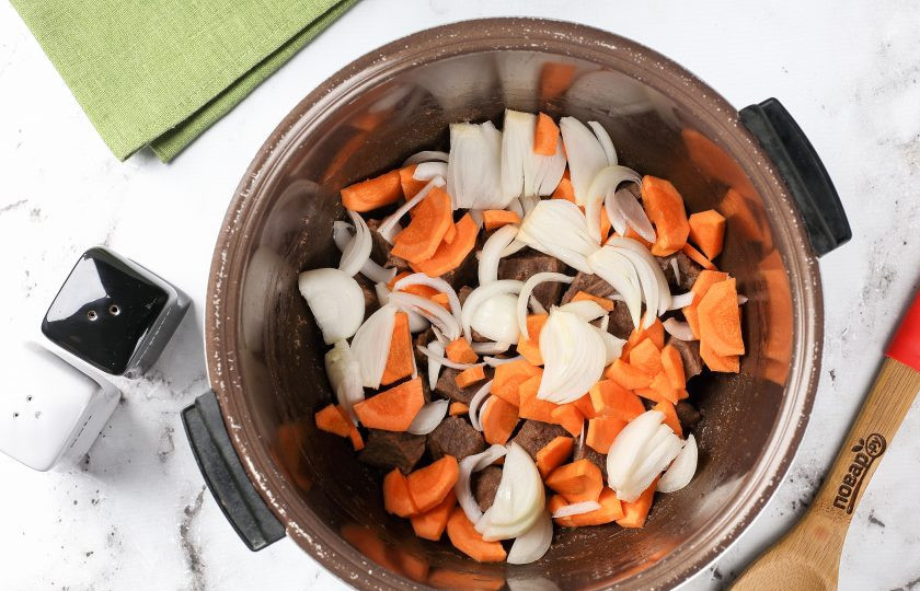 1. Этап. Томлёная говядина в мультиварке: Добавьте нарезанные лук и морковь. Нарезка может быть любая, но не мелкая, так как овощи при длительном томлении превратятся в густой соус и вкуснее будет, если они останутся небольшими кусочками.