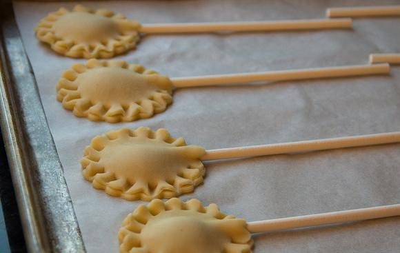 1. Этап. Мини-пирожки на палочке: 4. Собрать оставшееся тесто и обрезки. Вырезать еще 24 кружка и выложить их сверху. Отломать кусок ненужной палочки и сделать рифленые края у мини-пирожков, соединяя их друг с другом.