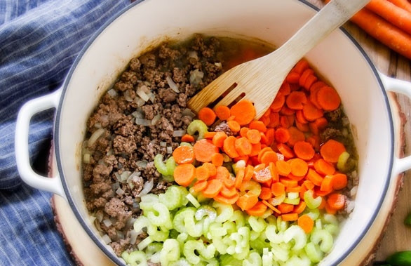 1. Этап. Итальянский обед: 1. Очистите лук и нарежьте его мелко, обжарьте фарш с луком в кастрюле до готовности. Тем временем очистите и нарежьте кружочками морковь, сельдерей. Добавьте овощи к обжаренному мясу.