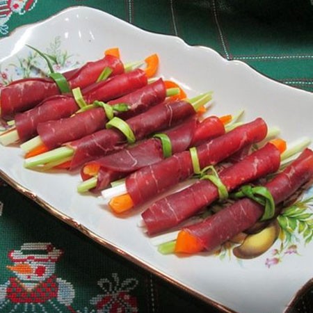 1. Stage. Bresaola rolls with vegetables: Roll and tie with green onions.