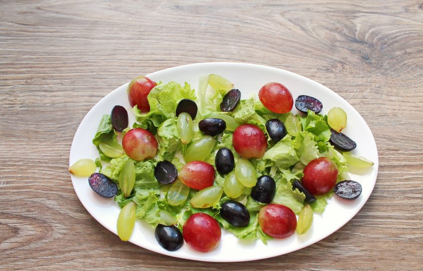 1. Этап. Салат Дор блю с виноградом: Виноград разрежьте пополам. Если необходимо удалите зернышки и разложите на листья салата.