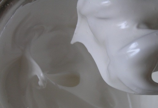 1. Этап. Кокосовый торт-безе с ананасами: Приготовьте безе. Разогрейте духовку до 130*C. На противень для выпечки положите пекарскую бумагу и нарисуйте два круга диаметром около 20 см. Белки взбейте, постепенно добавляя сахар, тщательно взбивая после каждой добавки сахара. Белковая масса должна стать густой и блестящей. В конце добавьте крахмал и лимонный сок и взбейте еще одну минуту.