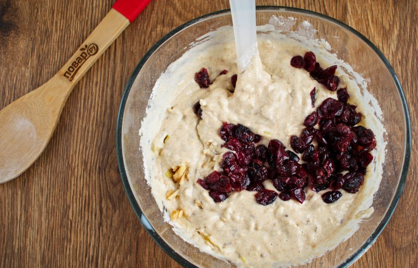 1. Этап. Полезные маффины для детей: Добавьте смесь цельнозерновой муки, разрыхлителя и семян льна. Перемешайте лопаткой, сохраняя воздушность массы. Добавьте тертое яблоко, перемешайте. Затем вяленую клюкву, перемешайте.