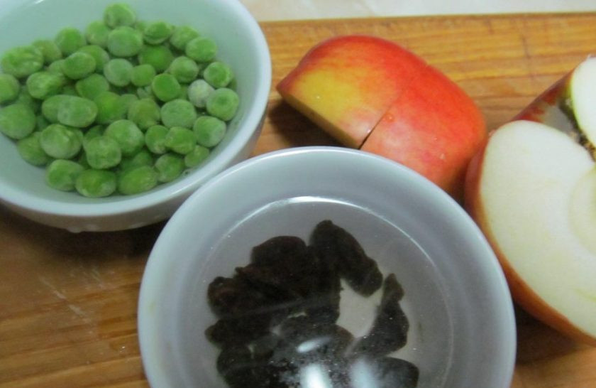 1. Этап. Салат из свежей капусты с горошком: Если горошек у вас замороженный, то залейте его кипятком на 5 минут. Также поступите с изюмом. Яблоко нарежьте дольками.