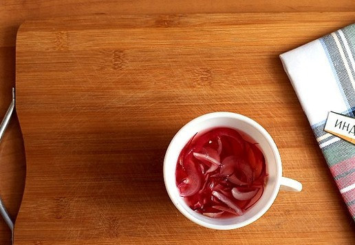 1. Этап. Салат из колбасы и редьки: Лук в оригинальном салате берётся репчатый. Я заменю его на крымский. Режем тонкими перьями, помещаем в чашку, заливаем кипятком и уксусом, добавляем сахар. Пусть промаринуется минут 15. Используйте свой лук, который делаете как заготовку к салатам. Я уксус использую белый винный.