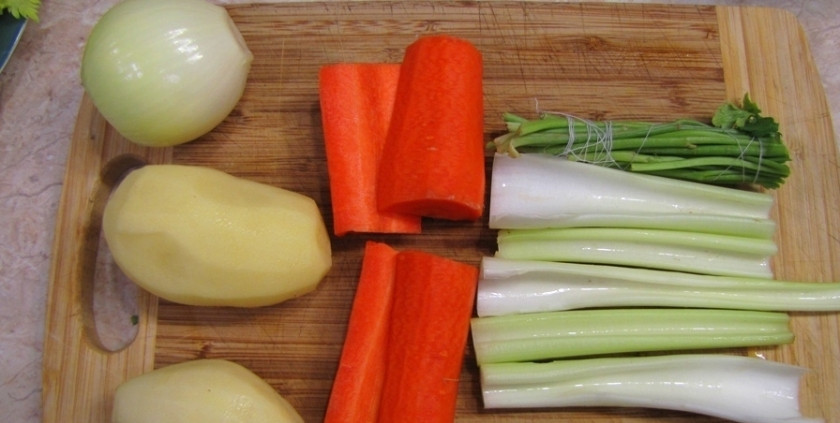 1. Этап. Уха из головы сазана: Приготовлением мы начинаем с овощного бульона. Для этого нам необходимо нарезать крупно морковь и сельдерей, почистить картофель, а в лук воткнуть гвоздику. Так же мы отрезаем стебли петрушки и связываем их нитью.