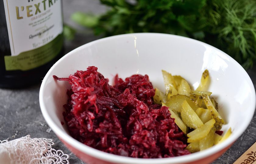 1. Этап. Свекла по-царски: Весь процесс простой и быстрый, главное заранее отварить и почистить свеклу. Натрите свеклу на крупной терке, кислый или маринованный огурец нарежьте мелкой соломкой, выложите овощи в глубокую миску.