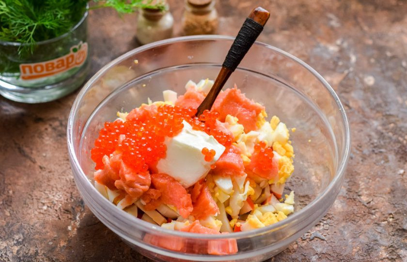 1. Этап. Салат Нептун с красной икрой: Добавьте в салат 30 грамм икры, майонез, соль и перец. Оставшуюся икру используйте для подачи.