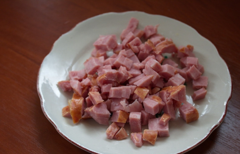1. Этап. Закуска из ветчины и сыра: Ветчину нарезать на кубики небольшого размера. Слишком крупные кусочки закуски будут торчать из тарталеток. Приятнее и вкуснее, когда все нарезано мелко.