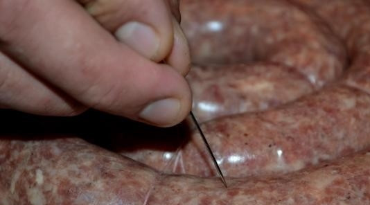 1. Этап. Колбаски из говядины: 7. После того, как колбаска перевязана, резко сделайте проколы оболочки новой иглой от одноразового шприца. Затем сложите кружки колбасы в воду. Дополнительно посолите и добавьте лавровый лист. После закипания убавьте огонь. Накройте крышкой. Варите на медленном огне 30-40 минут.