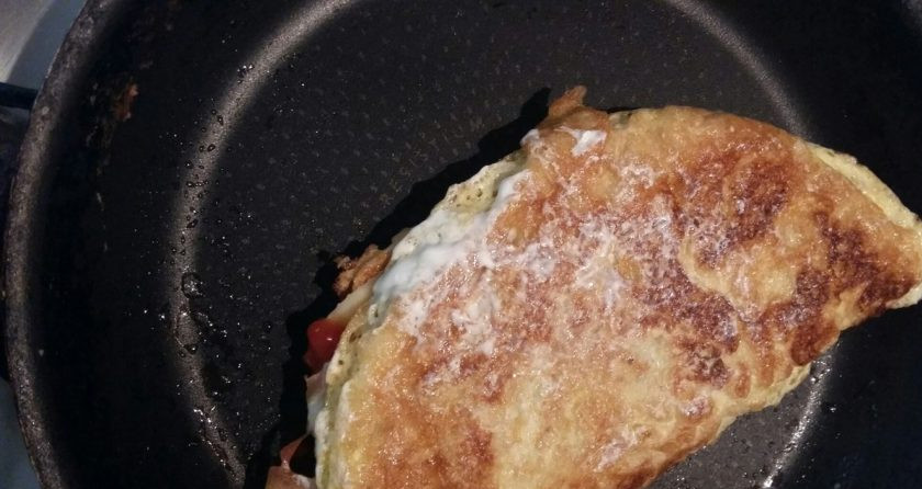 1. Этап. Омлет с овсяной кашей: Сверните омлет конвертиком, накройте сковороду крышкой и на маленьком огне поджаривайте омлет еще пару минут, чтобы сыр расплавился.