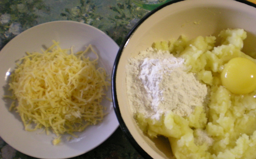 1. Этап. Картофельные корзиночки с начинкой: 1. Картошку отварим и потолчем до пюреобразного состояния. Теперь к пюре добавим желток, половину от всего сыра, муку и специи по вкусу.