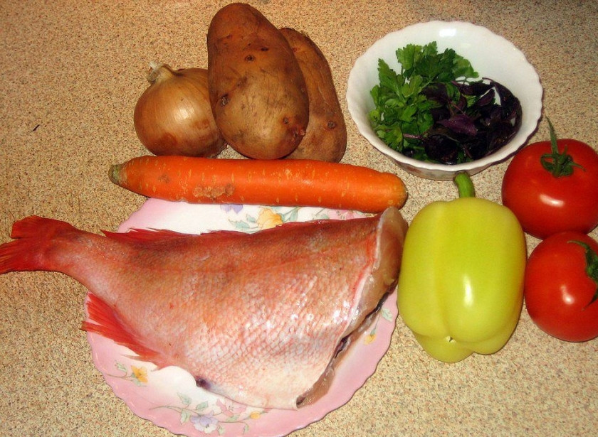 1. Этап. Морской окунь запеченный: Подготовим все необходимые ингредиенты. Овощи хорошенько промоем под проточной водой. Картошку, лук, морковь очистим от кожуры. Зелень нарежем. Окуня разморозим при комнатной температуре. Отрежем голову и держа рыбу за хвост, очищаем от чешуи. Вынимаем внутренности окуня. Внутреннюю полость рыбы хорошенько промываем, ножом очищаем от черной пленки (!).