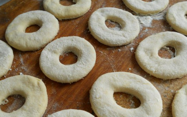 1. Этап. Пончики на кефире: Формочкой или стаканом вырезаем из теста кружочки. В центре каждого кружочка вырезаем отверстие.